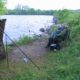 Two people fishing by a lakeside.