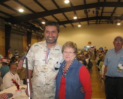 Man and woman smiling at indoor event.