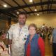 Man and woman smiling at indoor event.