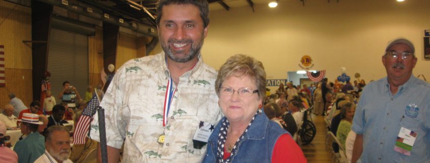 Man and woman smiling at indoor event.