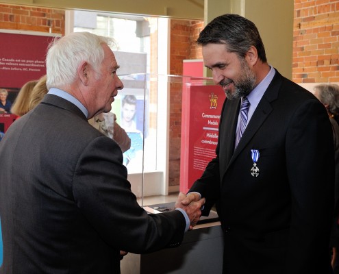 Two men shaking hands at a formal event.