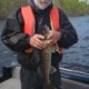Man holding a fish on a boat.