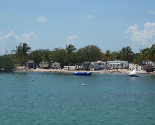 Boats docked near a coastal town with calm blue waters.