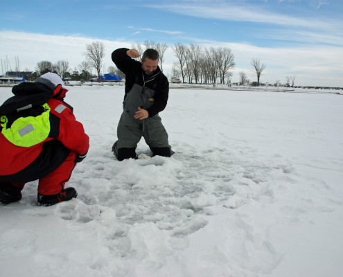 Two people playing in the snow on a bright winter day.