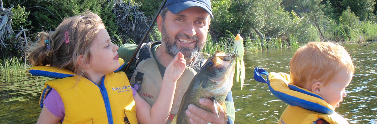 Man holding a large fish with a smile.