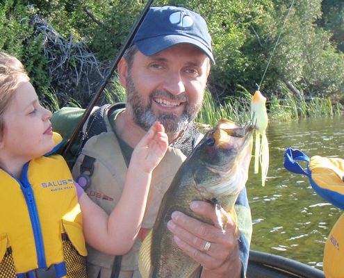 Man holding a large fish with a smile.
