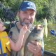 Man holding a large fish with a smile.