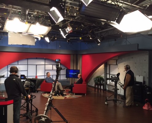 A modern gym with weightlifting and cardio equipment under a stylish ceiling.