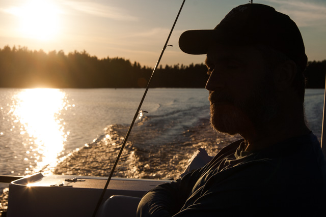 Lawrence sitting in a boat at sunset