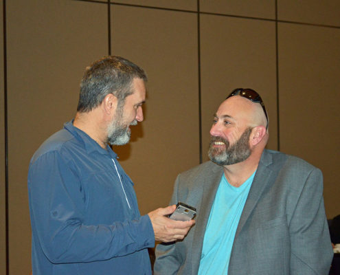 Two men engaged in a conversation indoors.