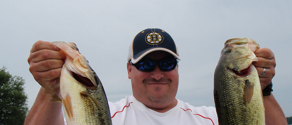 Nigel holding two Bass heading for the weigh-in bag