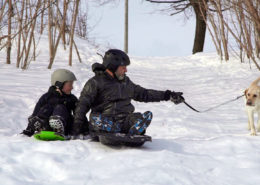 Theo and Lawrence sledding with Sherman