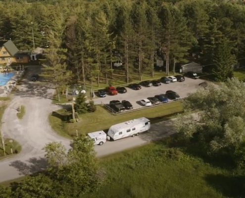 Aerial view of a caravan park surrounded by dense forest.