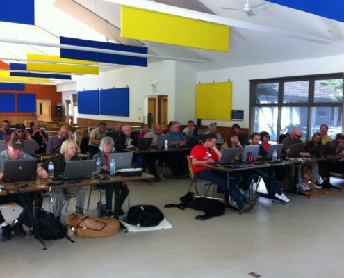 People working in a spacious, colorful office with computers and laptops.