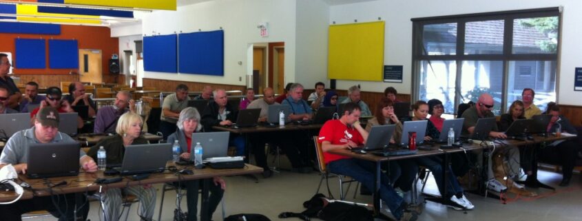 People working in a spacious, colorful office with computers and laptops.