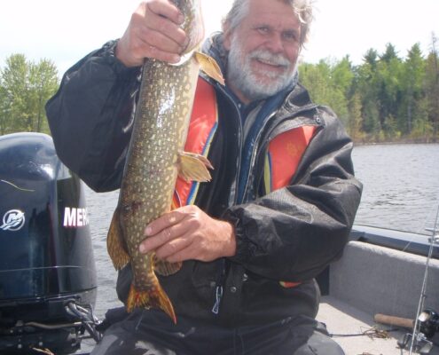 Man holding a large fish on a boat.