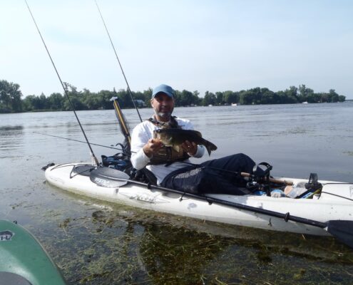 A person fishing alone on a small boat in calm waters.