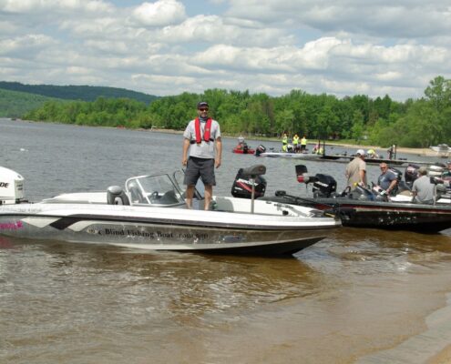 People on a motorboat near a shore on a cloudy day.