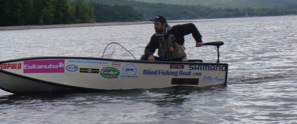 Person paddling a kayak on calm water near hills.