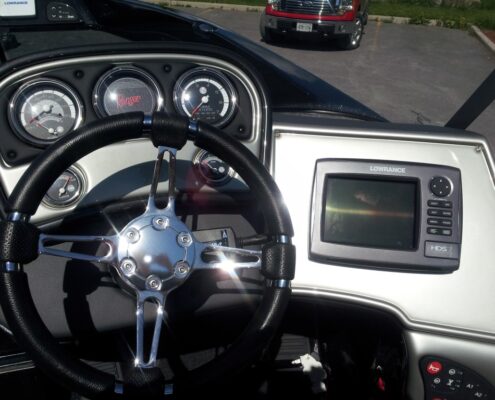 Car dashboard with steering wheel and touchscreen display.