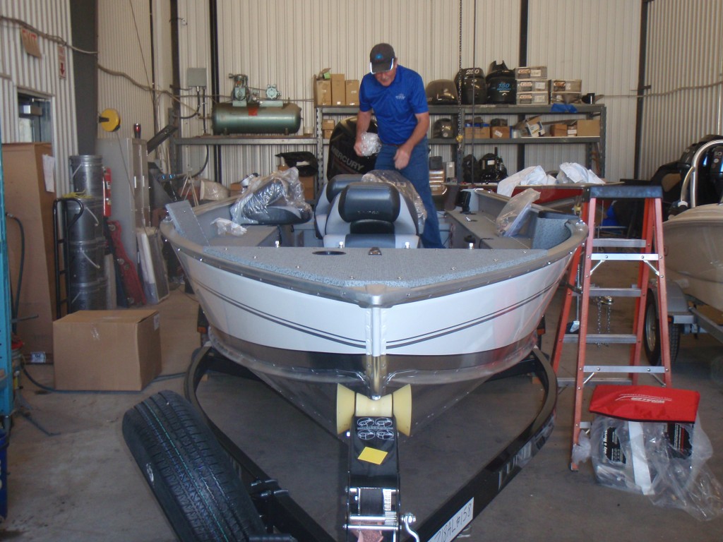 A motorboat docked indoors with various equipment on board.