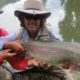 Two people holding a large fish outdoors.
