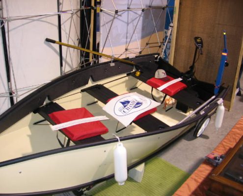 Small boat with red seats on display.
