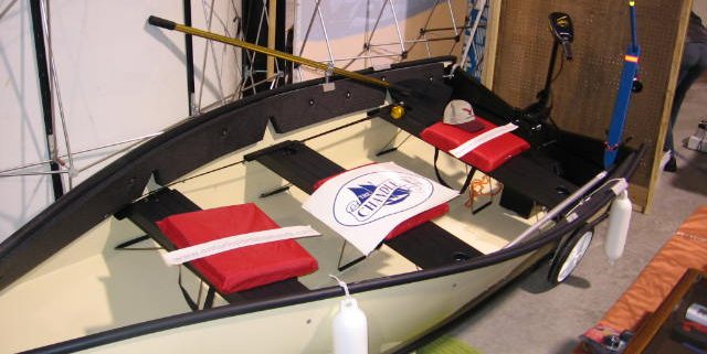 Small boat with red seats on display.